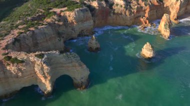 Marinha Sahili, Algarve, Güney Portekiz 'deki Doğal Kemer' in havadan görünüşü. Oyulmuş sahil şeridindeki kayalık yamaçlar. Yüksek kalite 4k görüntü