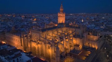 Sevilla 'nın Gece Gotik Katedrali, İspanya' nın Endülüs kentindeki Sevilla Eski Kasabası 'ndaki Giralda çan kulesiyle Hava Çekimi. Yüksek kalite 4k görüntü