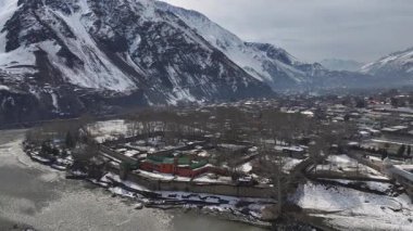 Pakistan 'ın Chitral kentindeki tarihi bir kalenin kışın havadan görünüşü. Kalash Vadisi 'ndeki nehir kıyısında parlak bir bina. Yüksek kalite 4k görüntü