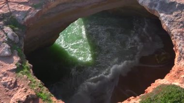 Akşam Portekiz 'de Benagil Mağarası. Okyanus Dalgaları Güney Portekiz, Algarve 'deki bir mağara kumsalında yuvarlanıyor. Yüksek kalite 4k görüntü