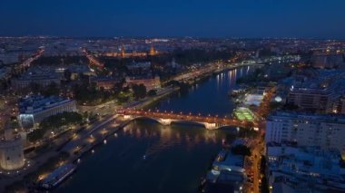 Sevilla 'daki Guadalquivir nehri Eski Gece Kasabası, Hava Triana Köprüsü, Şehir Aydınlatma. Sevilla, Endülüs, İspanya. Yüksek kalite 4k görüntü