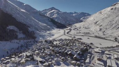 Andermatt, İsviçre, kışın. Kar yağdıktan sonra güneşli bir günde İsviçre 'nin Kanton Uri Alplerindeki dağ köyünün havası. Yüksek kalite 4k görüntü