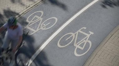 Bisikletlerin Almanya 'nın Konstanz şehrinde beyaz bir bisikletin sembolünü geçirdiği mavi gölgeli bisiklet yolunun en üst görüntüsü. Yüksek kalite 4k görüntü