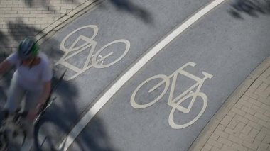 Bisikletlerin Almanya 'nın Konstanz şehrinde beyaz bir bisikletin sembolünü geçirdiği mavi gölgeli bisiklet yolunun en üst görüntüsü. Yüksek kalite 4k görüntü