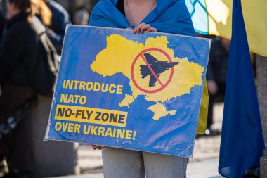 Krakow 'da bir kadının taşıdığı Ukrayna tabelasının üzerinde NATO uçuşa yasak bölgesini tanıt. Polonya 'da Ukrayna' nın desteğiyle dur. Krakow, Polonya - 10 Kasım 2022.