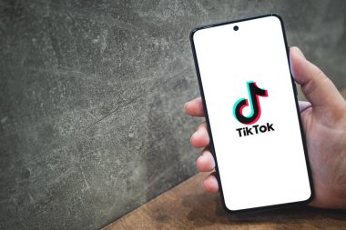 Akıllı telefon ekranında Tik tok uygulama logosu, metin için kopyalama alanı olan beton arka plan. Tiktok sosyal medya uygulama simgesi. Krakow, Polonya - 11 Kasım 2022.