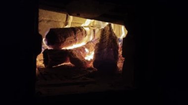 Dry firewood burns in a rural wood-burning brick stove. Fireplace close-up. Fire heating in the house.
