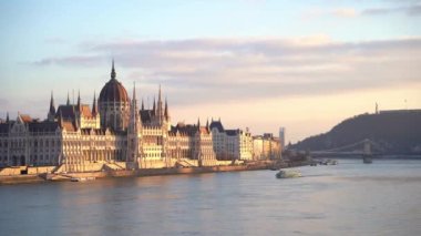 Hungarian parliament building at sunset, Budapest, Hungary. Danube River Cruise boat.