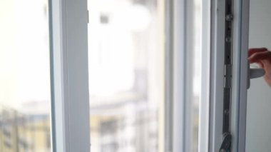 Man closes white plastic Pvc side hung inward Window.