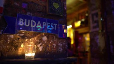 Interior of Szimpla Kert at night, famous ruin pub in Budapest, Hungary. Budapest tiles on grunge walls and a candle. Nightlife concept. Budapest, Hungary - February 2, 2023.