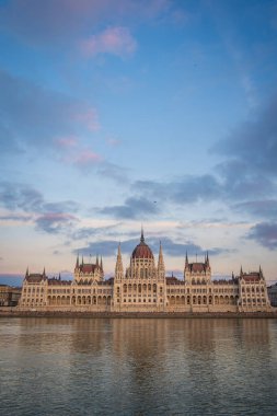 Budapest Parliament from across Danube river, Hungary. Beautiful blue evening sky with pink clouds.
