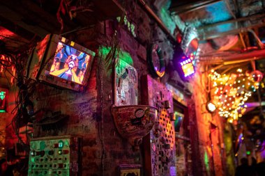 Interior of Szimpla Kert, famous ruin pub in Budapest at night. Old computer screens on the walls. Nightlife, hungarian bars concept. Budapest, Hungary - February 2, 2023.