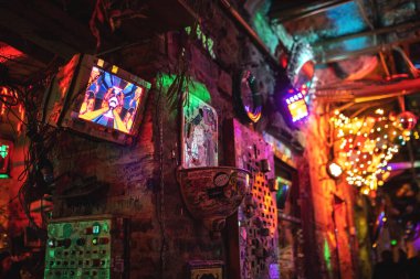 Interior of Szimpla Kert, famous ruin pub in Budapest at night. Old computer screens on the walls. Nightlife, hungarian bars concept. Budapest, Hungary - February 2, 2023.
