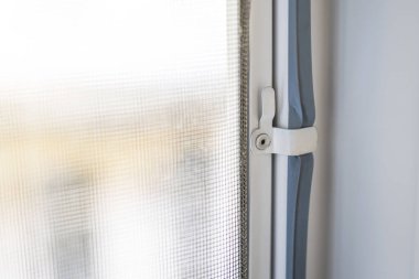 Anti Mosquito Net installation on Window to protect from insects, fixing hook close-up.