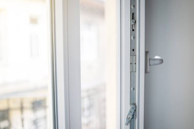 White plastic window frame with fittings close-up. Upvc windows and doors accessories and hardware.