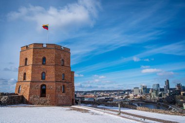 Litvanya Bayrağı, Mavi Gök 'e karşı Gediminas Kalesi' nde dalgalanıyor. Şehir merkezi ve nehir kışın güzel manzarası. Vilnius, Litvanya - 9 Mart 2023.