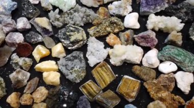 Gemstone mağazasındaki birçok Rough şifalı kristalin üst görüntüsü. Parlak Kaplan Göz, Amethyst, Citrine, Creedite, Smoky Quartz, Fuchsite ve diğer Satılık Yarı Değerli Taşlar.