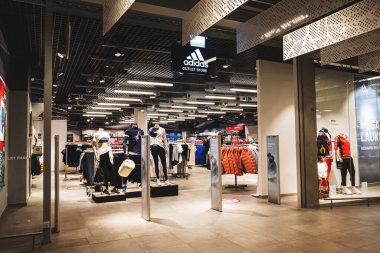 Alışveriş merkezinde logosu olan Adidas Outlet mağazası girişi. Adidas AG Avrupa 'da bir Alman spor giyim üreticisi. Vilnius, Litvanya - 8 Mart 2023.