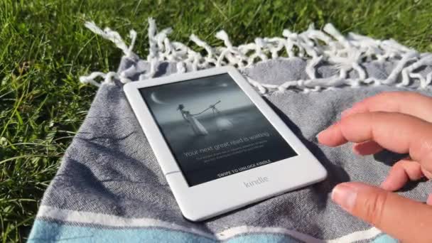 White Amazon Kindle Book Kocu Piknikowym Trawie Zewnątrz Zbliżenie Ręcznie — Wideo stockowe