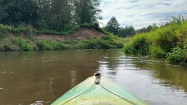 Yazın bir nehirde kano yaparken. Kayık yayı. Yeşil orman boyunca sakin su güzergahı olan güzel manzaralı nehre odaklan. İnsan yok. Watersport ve eğlence etkinliği konsepti.