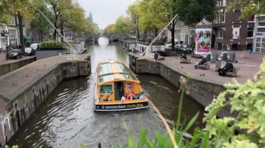 Amsterdam Korte Prinsengracht Kanalı. İnsanlar sonbaharda Gündüz Kanal Gezisi için Tur Teknesinde yelken açarlar. Geleneksel Hollanda evleri. Amsterdam, Hollanda - 23 Ekim 2023