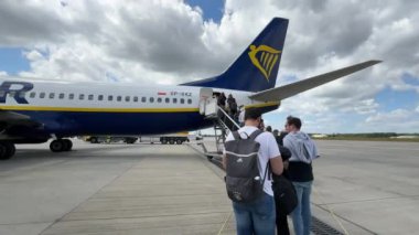 Ryanair uçağı Boeing 737 Varşova Modlin Havaalanı WMI 'da uçuşa hazırlanıyor. Seyyar merdivenden inen yolcular. Modlin, Polonya - 14 Haziran 2024