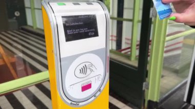 Hollanda tren istasyonu Hollanda 'daki OV-Chipkaart mavi toplu taşıma çipi kartıyla giriş yapıyor. Heemstede, Hollanda - 19 Haziran 2024.