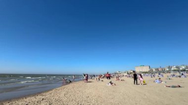 Zandvoort aan Zee bir yaz günü kumsalda kalabalıktı. İnsanlar popüler Hollanda tatil köyünde takılıyor. Zandvoort, Hollanda - 22 Haziran 2024.