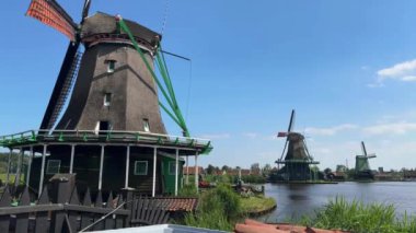 Zaanse Schans yazın Zaan nehrindeki geleneksel Hollanda yel değirmenleri. Amsterdam yakınlarındaki popüler turizm merkezi. Zaandam, Hollanda - 22 Haziran 2024.