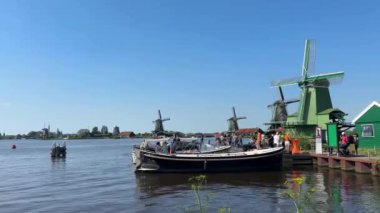 Zaanse Schans 'ta Zaan Nehri' nde geleneksel Hollanda yel değirmenleriyle tekne turu. Amsterdam yakınlarındaki popüler turizm merkezi. Zaandam, Hollanda - 22 Haziran 2024.