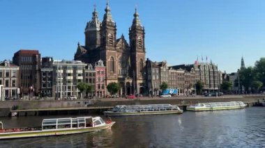 Amsterdam 'daki Aziz Niklas Bazilikası. Merkez İstasyon Kanal Tekne Gezileri. Amsterdam, Hollanda - 23 Haziran 2024.