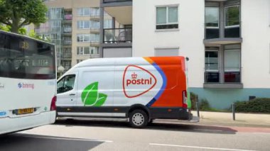 PostNL teslimat minibüsü caddeye park edilmiş. Hollandalı posta şirketi ve teslimat servisi. Nijmegen, Hollanda - 3 Temmuz 2024.