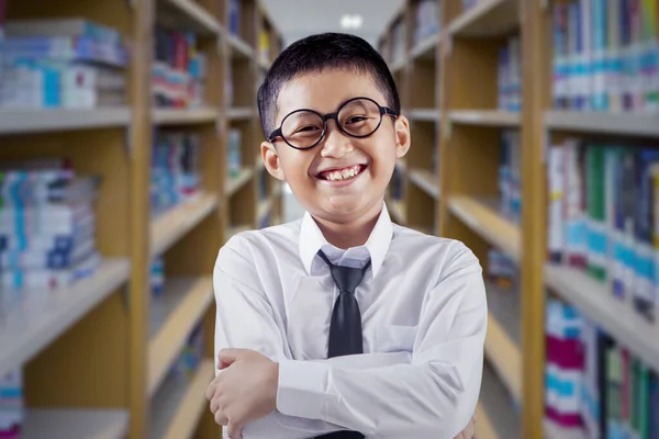 Веселый Школьник Перекрещивает Руки Стоя Библиотеке Книжной Полке — стоковое фото