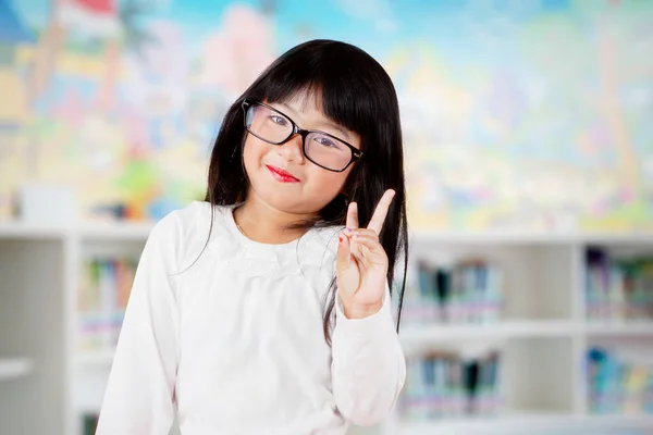 Aranyos Iskolás Lány Mutatja Győzelem Jele Miközben Áll Könyvtárban Homályos — Stock Fotó