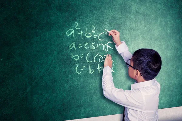 クラスの前に立っている間 黒板に数学の問題を解決するスマートスクールボーイ — ストック写真