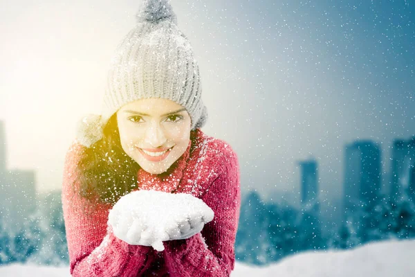 冬には雪を手にしながらニットセーターを着た笑顔の若い女性 — ストック写真