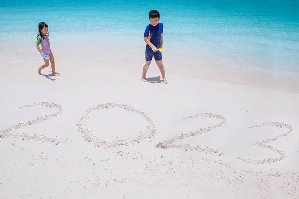 Tropikal Plajda Oynarken 2023 Numara Yazan Iki Küçük Çocuk — Stok fotoğraf