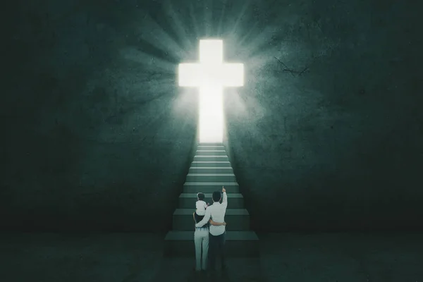 계단에서 동안밝은 십자가 모양을 가리키는 — 스톡 사진