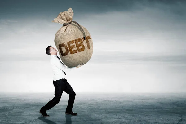 Homem Negócios Caucasiano Carregando Saco Dinheiro Com Palavra Dívida Enquanto — Fotografia de Stock