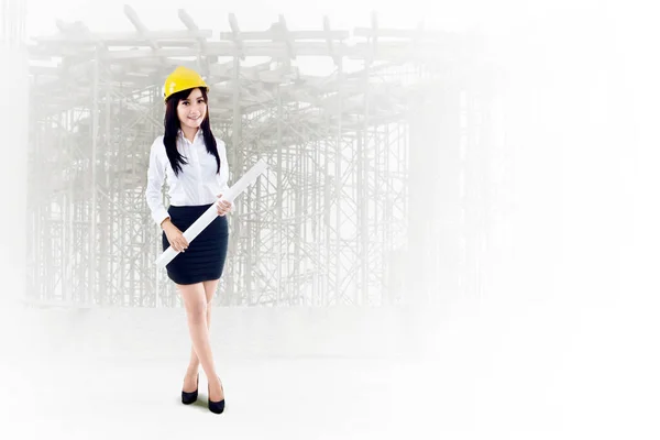 女性工程师手握蓝图 身兼建筑工地背景双重曝光 — 图库照片