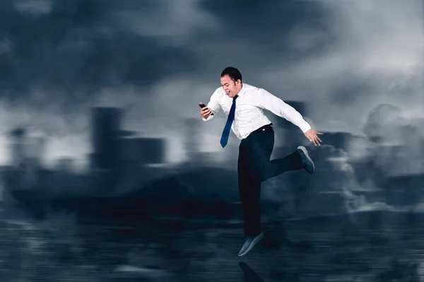 Geschäftsmann Mit Smartphone Beim Schnellen Laufen Mit Wolkenverhangenem Himmel — Stockfoto