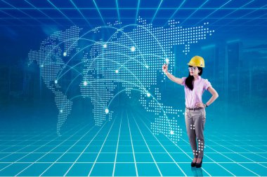 Güvenlik kasklı, dijital dünya haritalı Asyalı kadın.