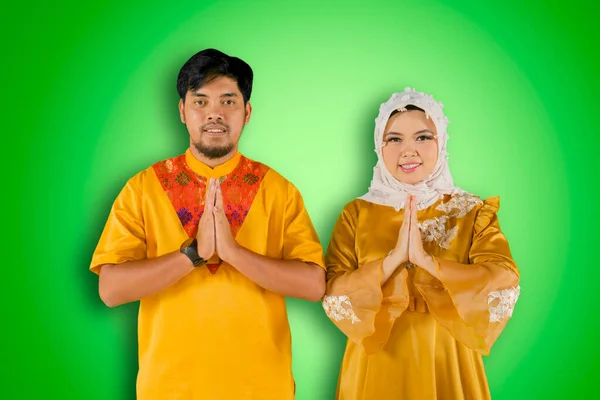 Genç Müslüman Çift Yeşil Arka Planda Bayram Kutlamaları Sırasında Hareketlerini — Stok fotoğraf
