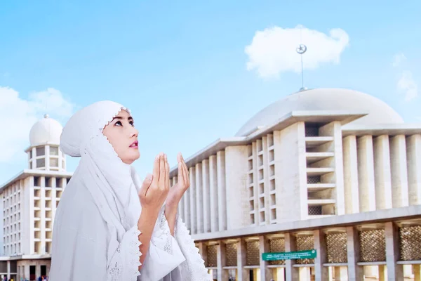 モスクを背景に祈る宗教的な女性の側面図 — ストック写真