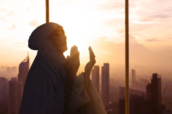 做完沙拉后向真主祈祷的穆斯林妇女的轮廓 — 图库照片