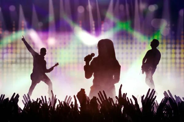 ステージ上で歌うバンド パーソナルズのシルエット 明るいステージライトの前でコンサート群集 — ストック写真