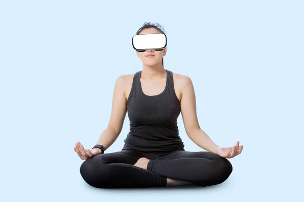年轻的女运动员头戴Vr耳机 在白色背景上做冥想 — 图库照片