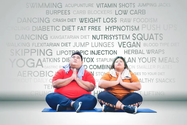 年轻的胖夫妇穿着运动服 一起做瑜伽运动 — 图库照片