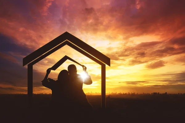 幸せなカップルのシルエット作る家で劇的な日没の背景 — ストック写真