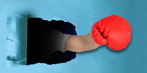 Man Knytnäve Boxningshandske Stansning Genom Blå Kartong Papper — Stockfoto